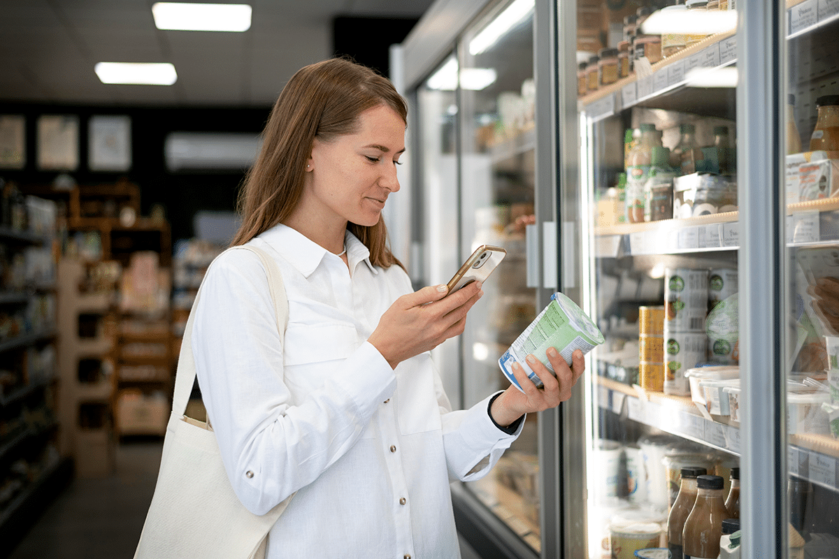 chica comprobando en un móvil información sobre un yogur