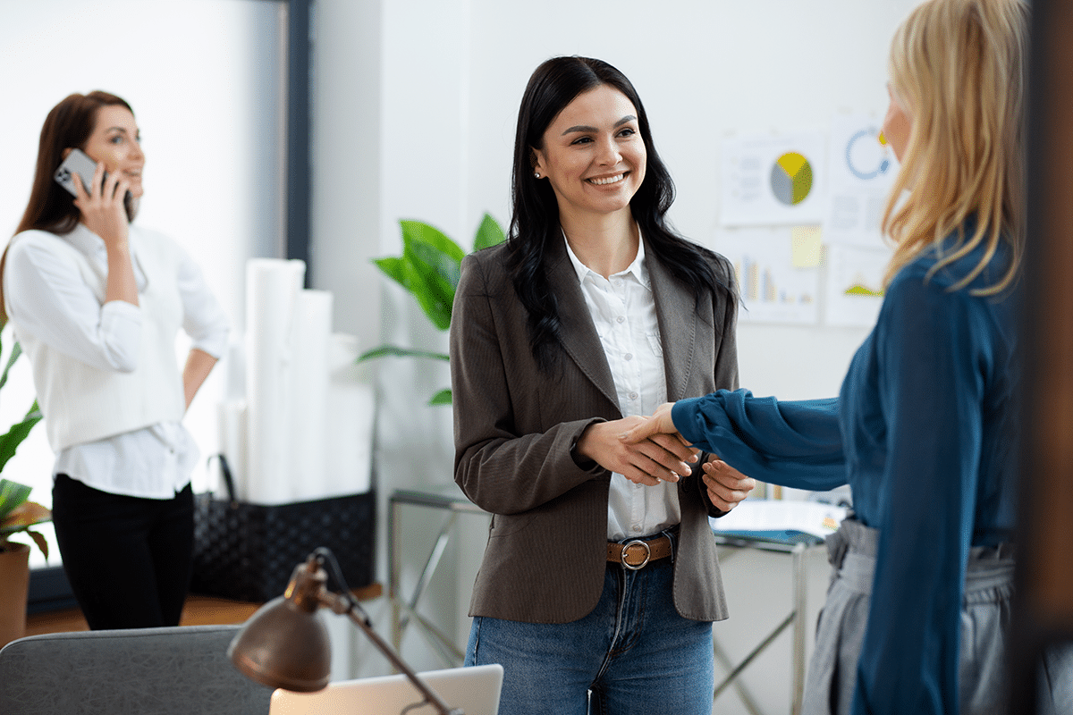 Dos chicas estrechándose la mano en una oficina